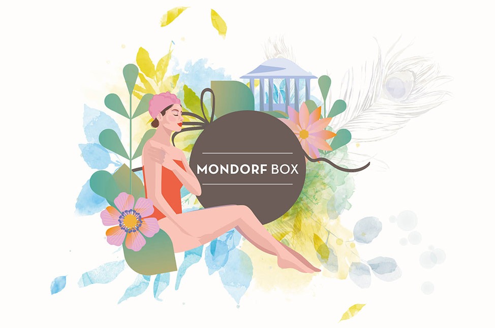 Ein lebhafter brauner Kreis mit dem Text "MONDORF BOX" in Weiß in der Mitte, umgeben von Aquarell-Blumenmustern in verschiedenen Blau-, Gelb- und Grau, die ein weiches und elegantes Gefühl erzeugen.Ein braunes Band wird subtil zur Komposition hinzugefügt.